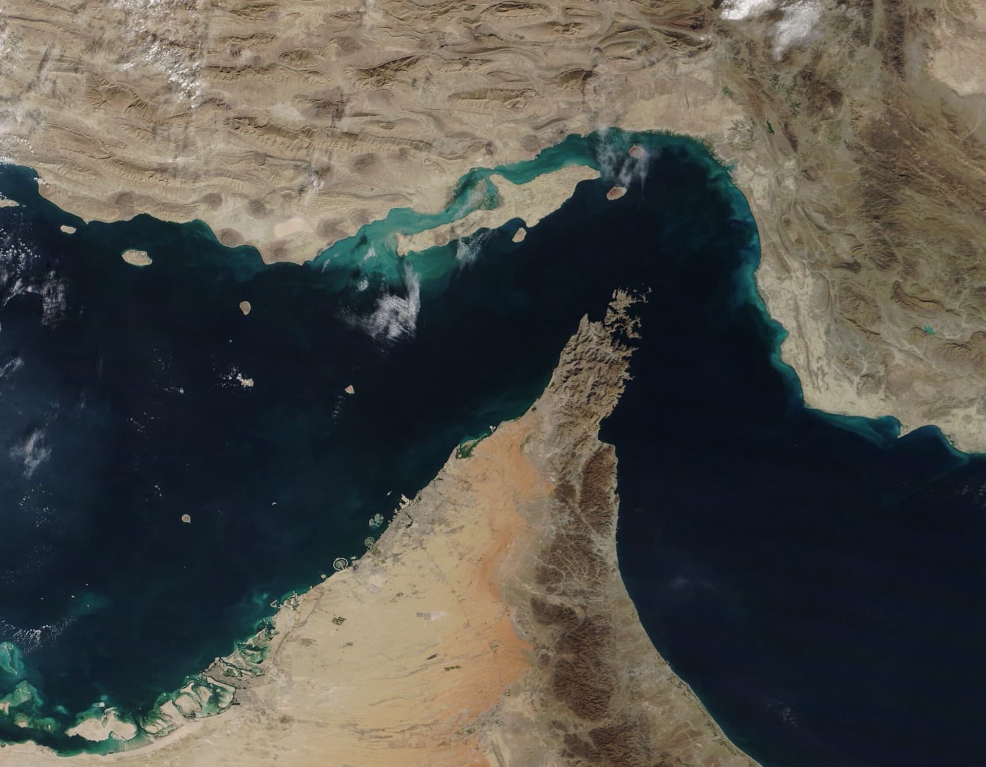 Satellite image of the Strait of Hormuz: Iran's coast and Qeshm island at the top, the Musandam peninsula of Oman and the UAE at the bottom, the Persian Gulf to the left and the Gulf of Oman to the right.